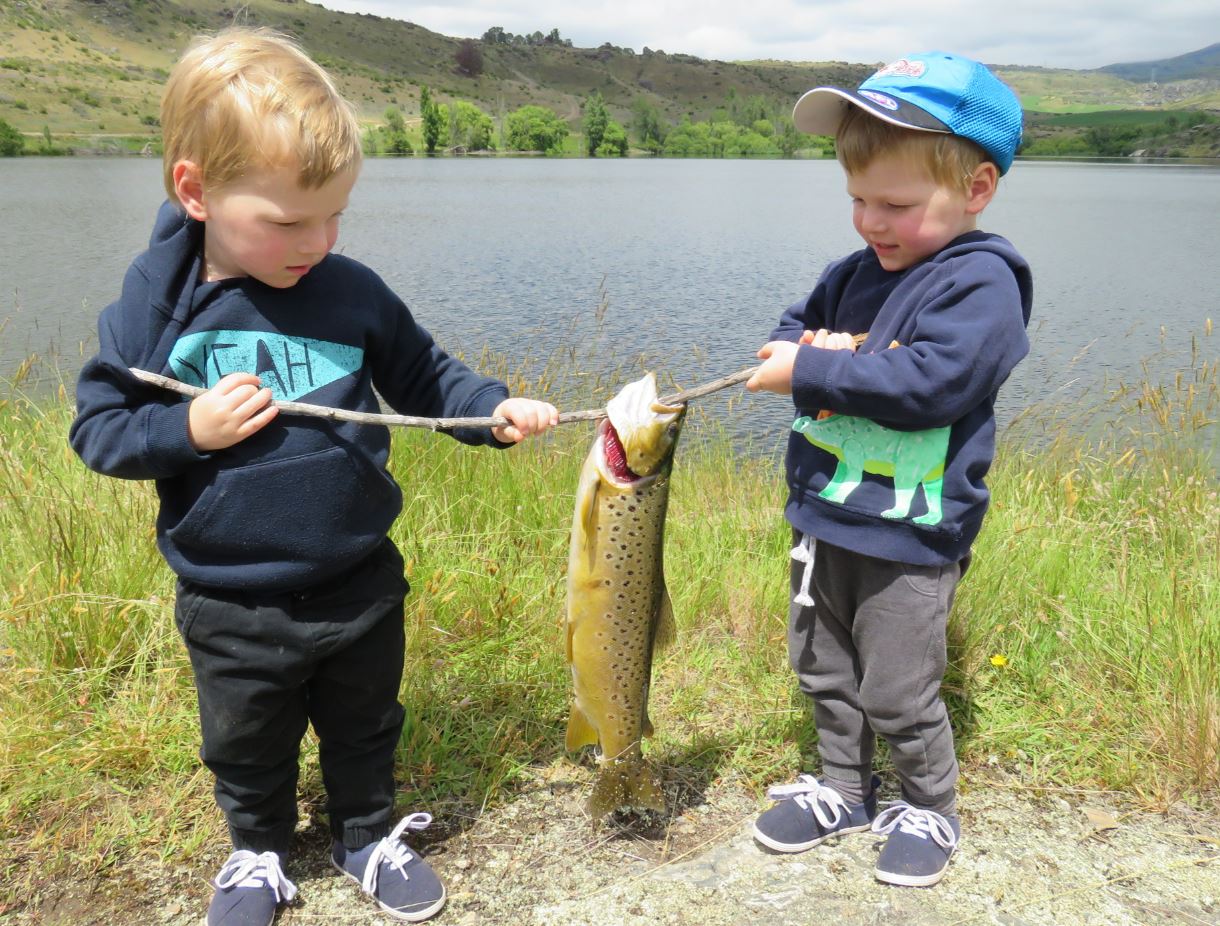 REEL LIFE FRONT PAGE TWINS with trout 3 year old twins Thomas and William Carroll with fat brown trout at Conroys Dam Central Otago
