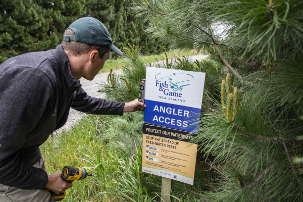 Harry Graham-Samson replaces an Angler Access sign near to the Rakaia Township